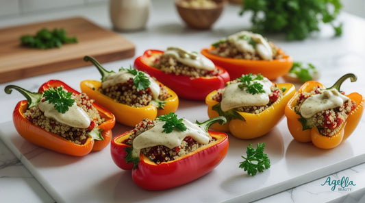 Mediterranean Quinoa Stuffed Peppers filled with fluffy quinoa, chickpeas, and sun-dried tomatoes, drizzled with creamy garlic tahini sauce and garnished with fresh parsley